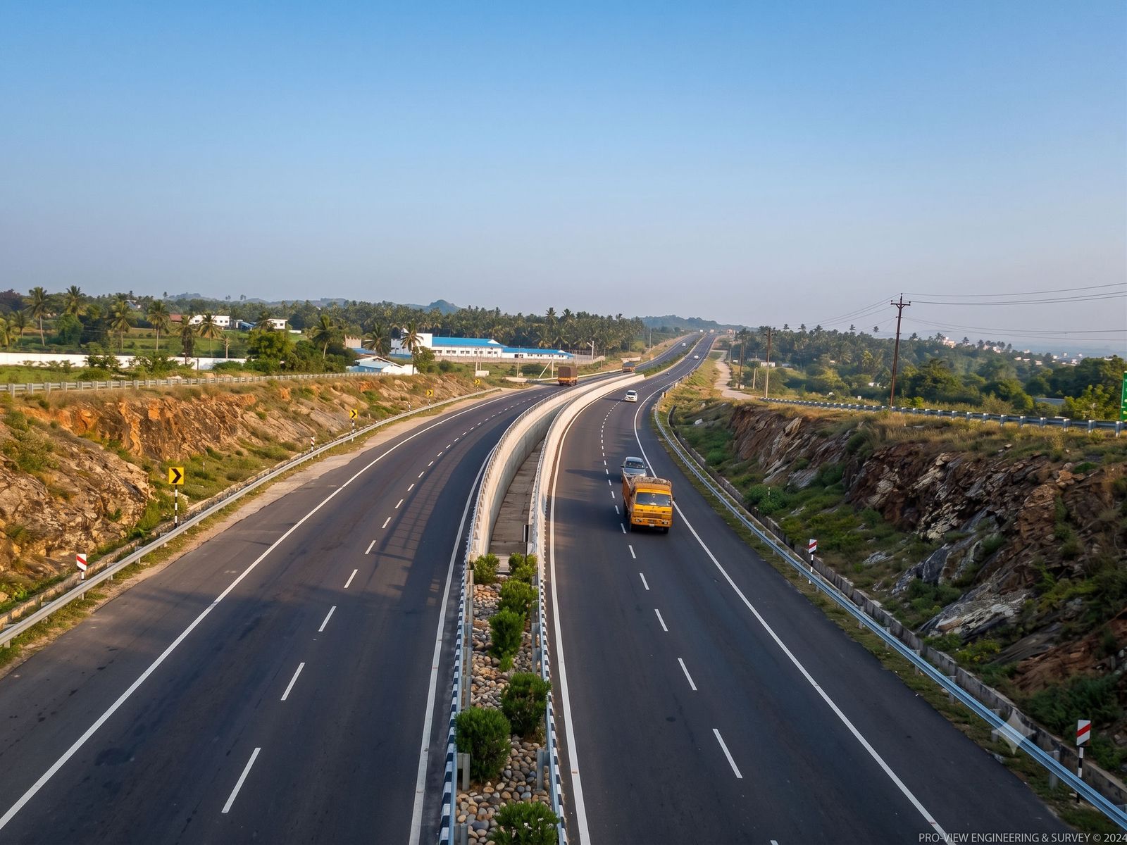 The divided four-lane highway curving through rocky hills on the road to Puttaparthi